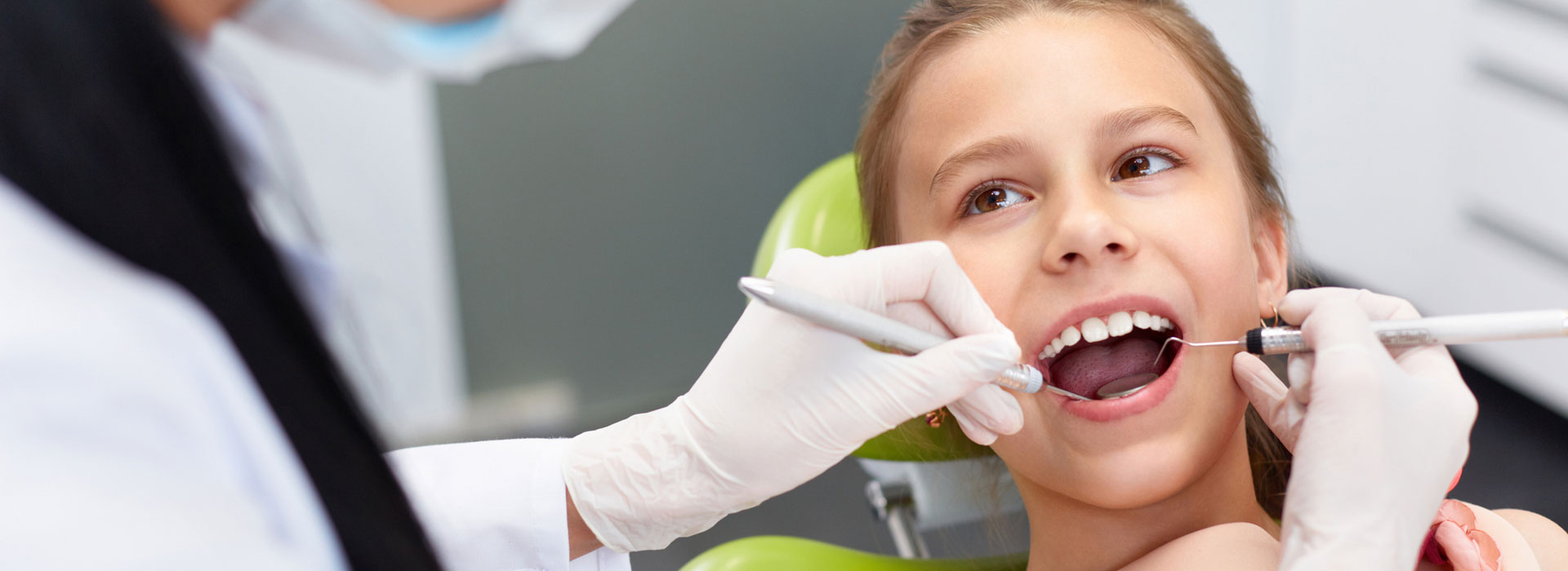 Dentist examining girls teeth